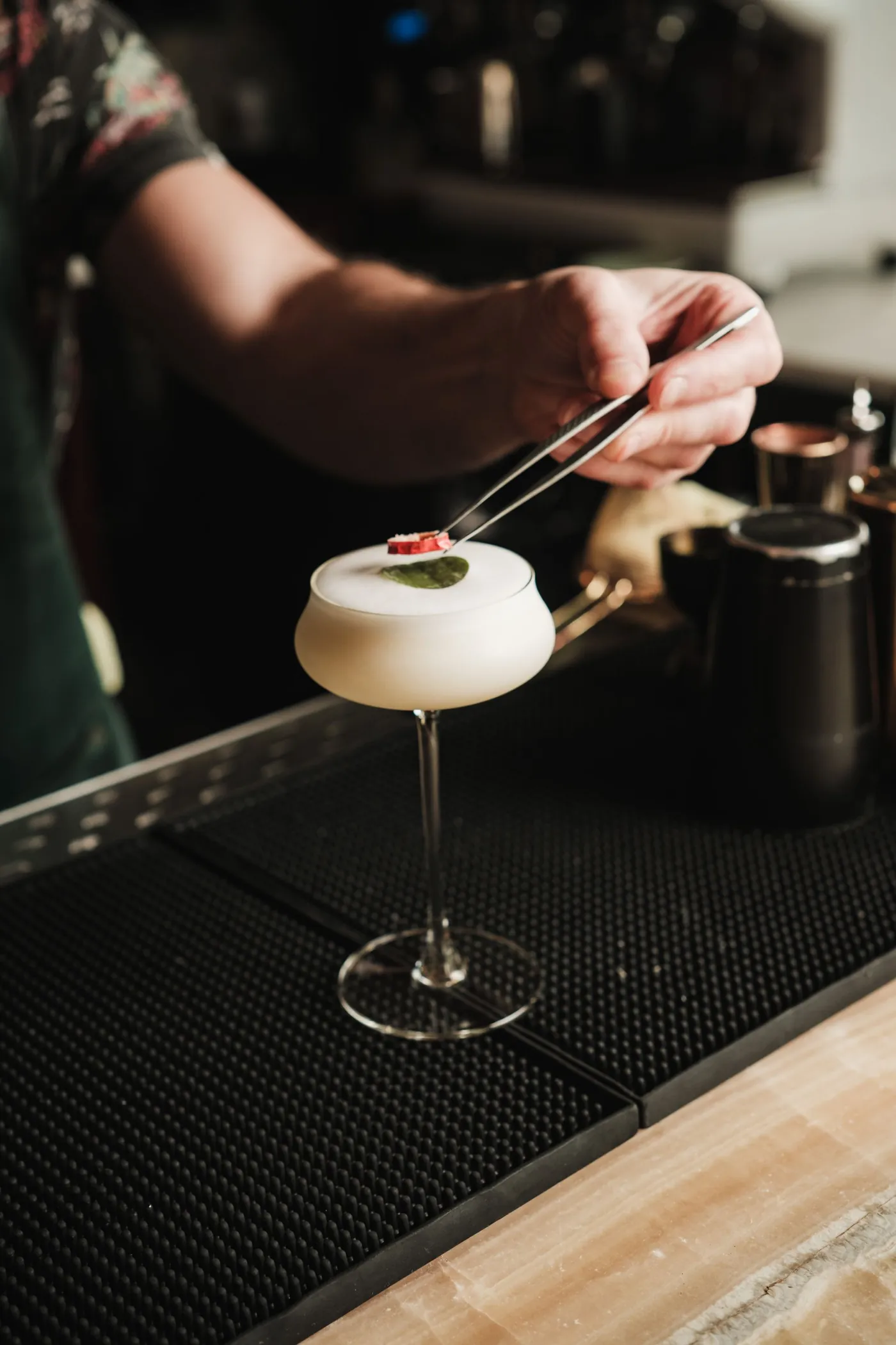 Barkeeper garniert einen Cocktail im Coupe-Glas