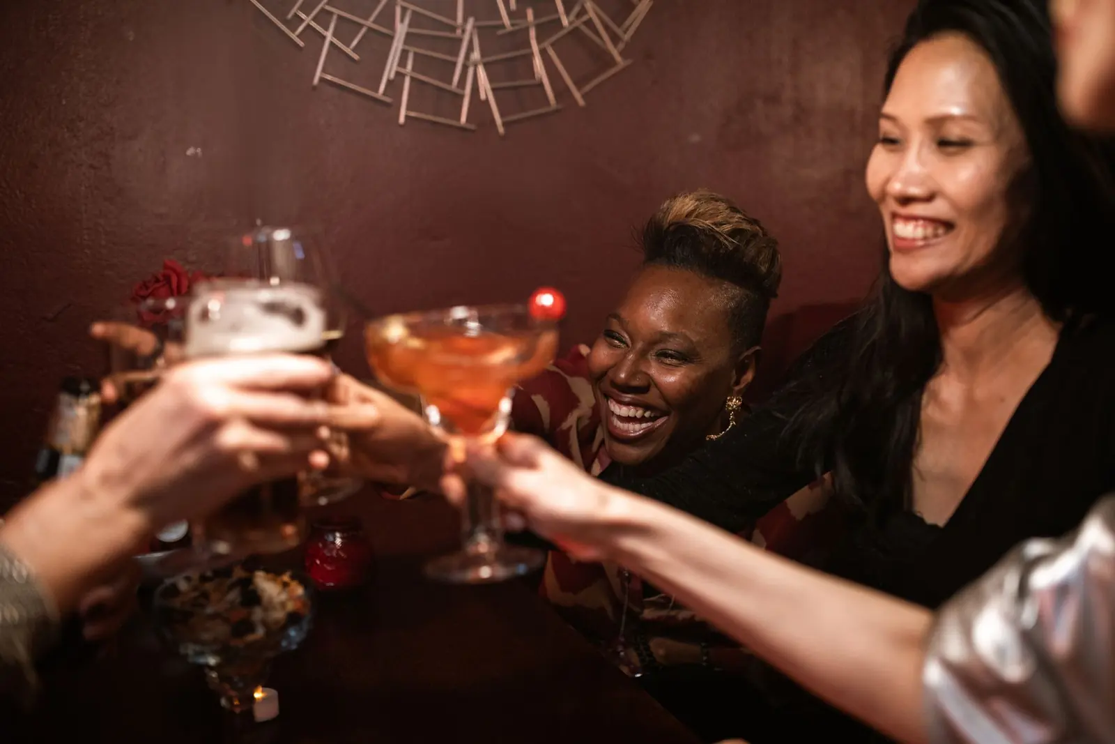 Freunde stoßen abends mit Cocktails an